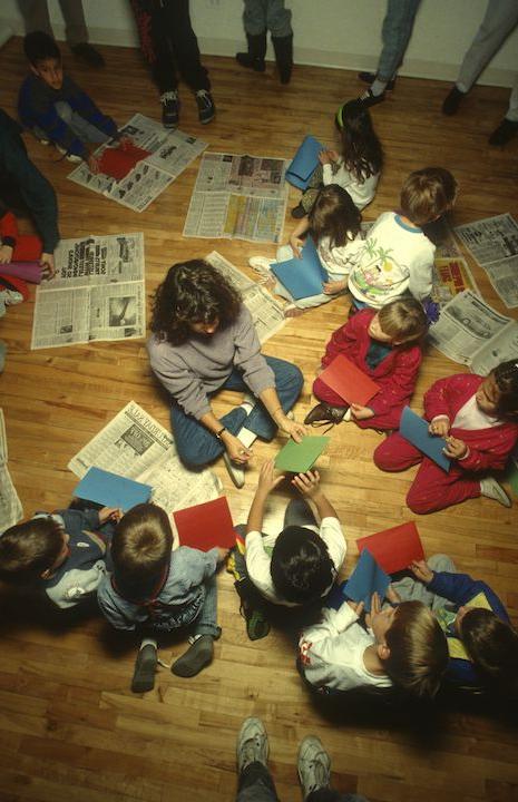 Overhead view of a teacher and students sitting on the floor