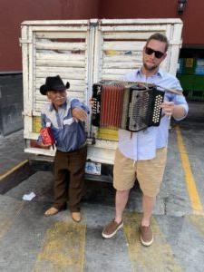 Travis Luther playing an accordion in Mexico