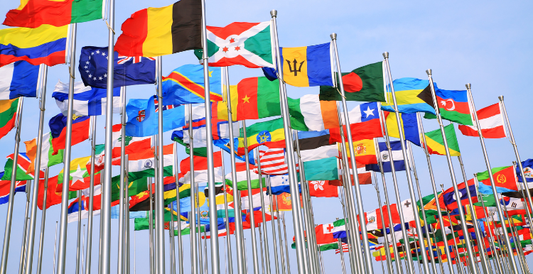 Flags from around the world flying on a pole.
